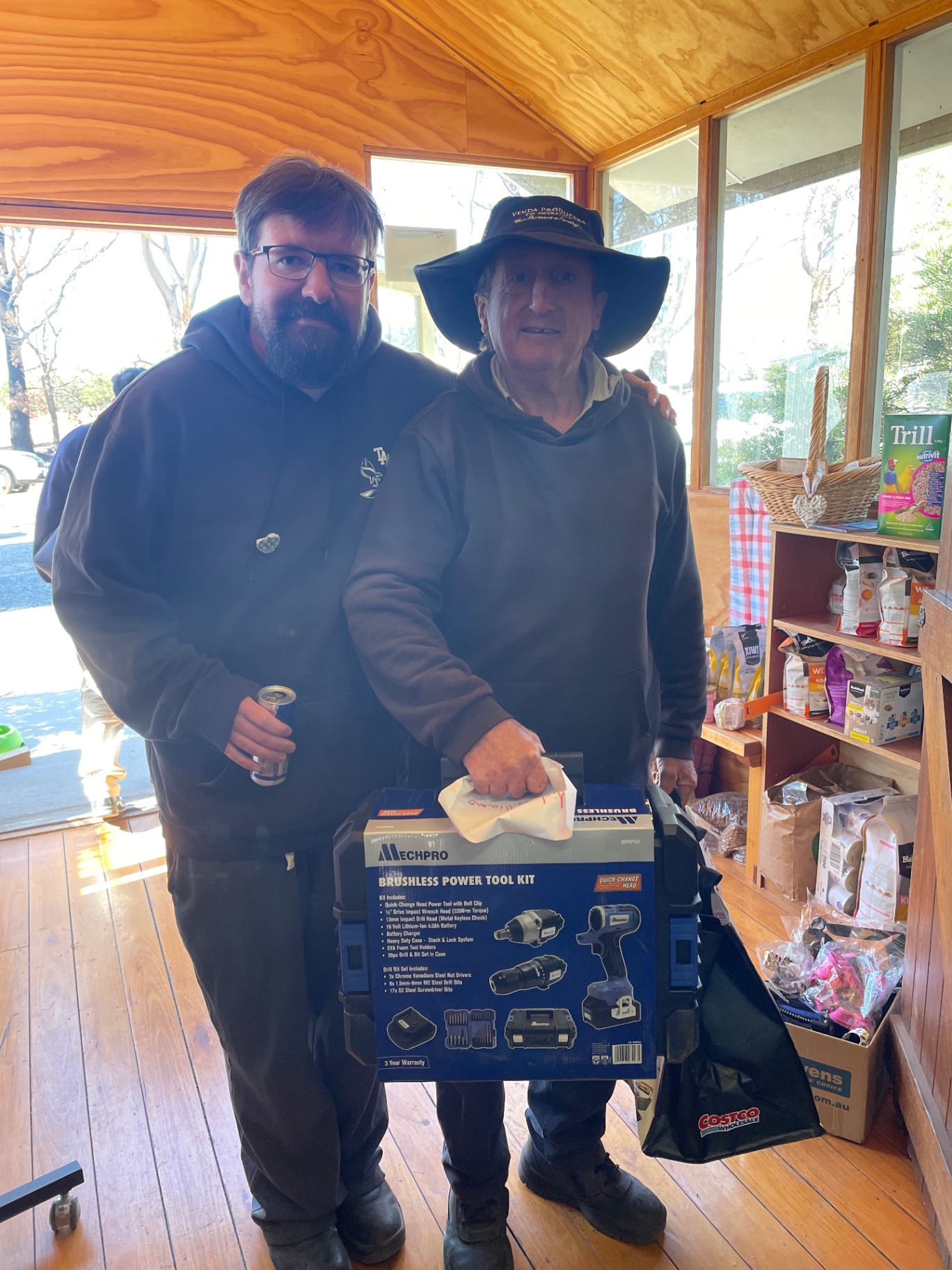 A volunteer handing over a donated power tool kit to a local resident