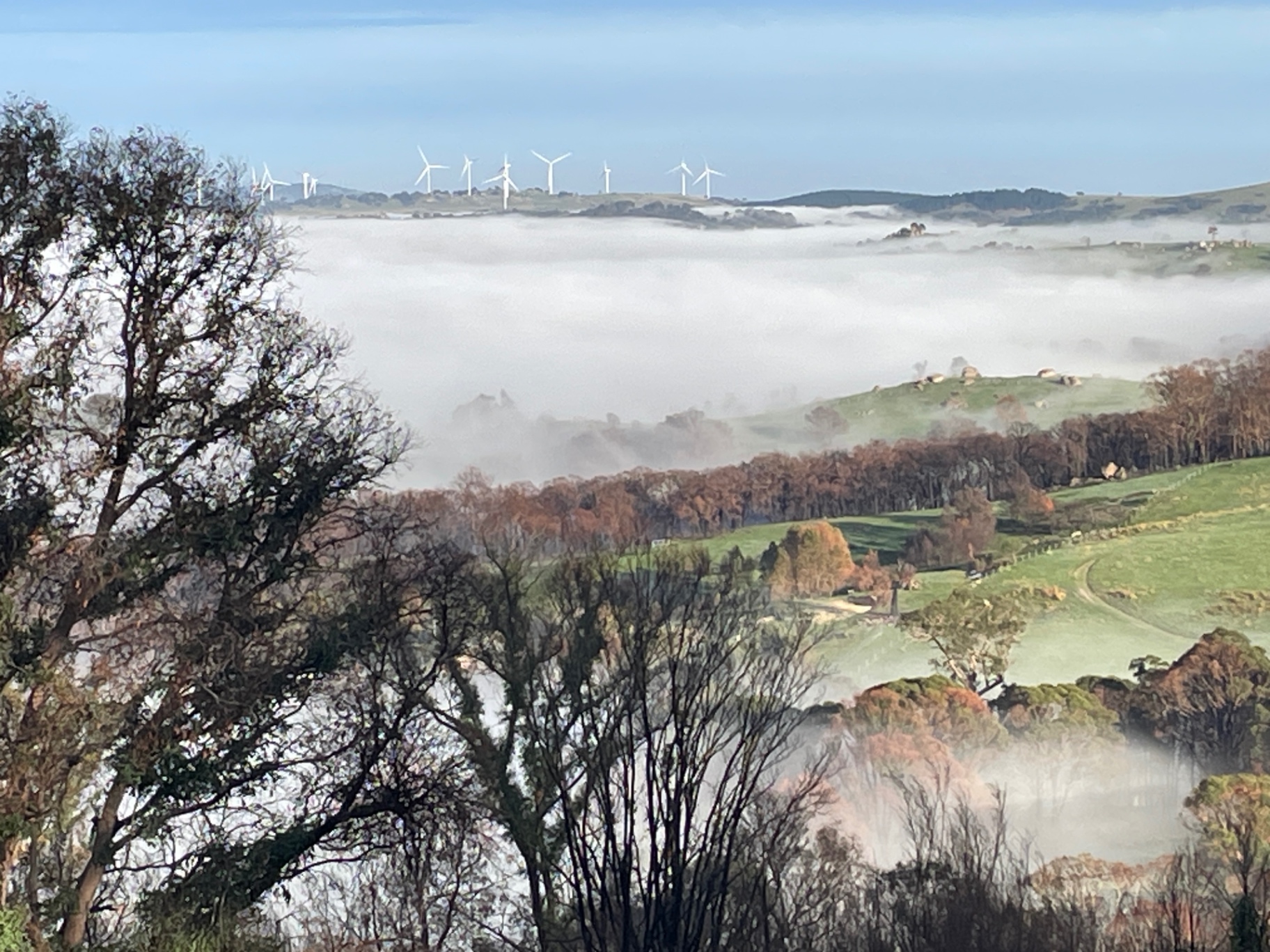 Fog settling over the Highlands valley with wind turbines on the far ridge